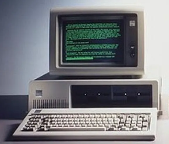 Photo of an old IBM PC with green on black CRT screen